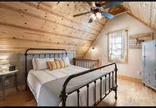 Relax and recharge in the upstairs primary bedroom featuring a comfortable queen bed and cozy linens.