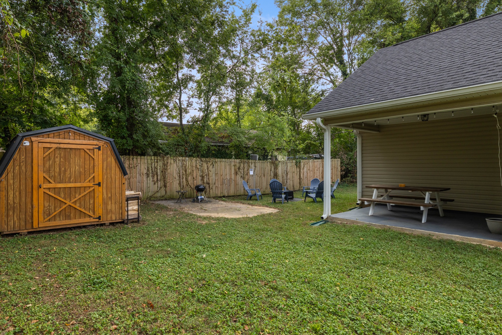 The Backyard Features a Spacious Lawn and Shaded Patio