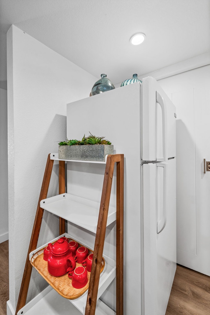 Your kitchen corner offers thoughtful touches like fresh succulents and a charming red tea set, ready for cozy mornings.