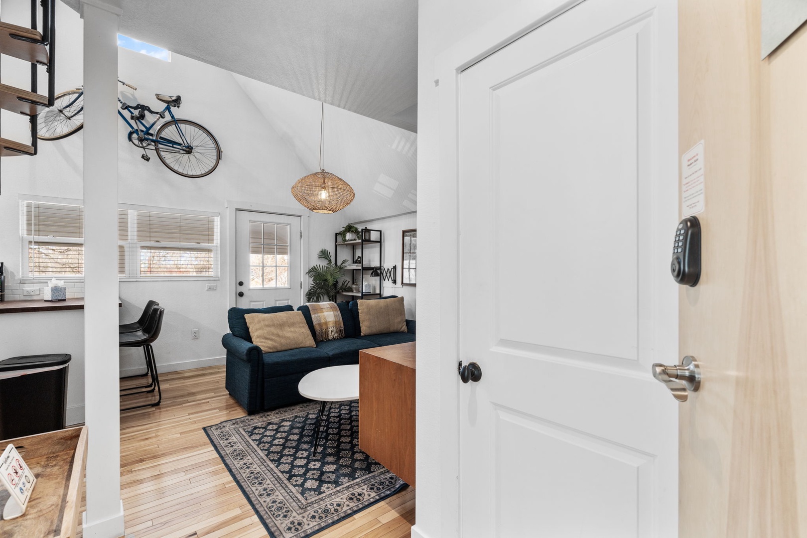 Your stylish loft features soaring ceilings, polished hardwood floors, and cozy seating beneath unique bicycle art—perfect for unwinding after exploring the city.