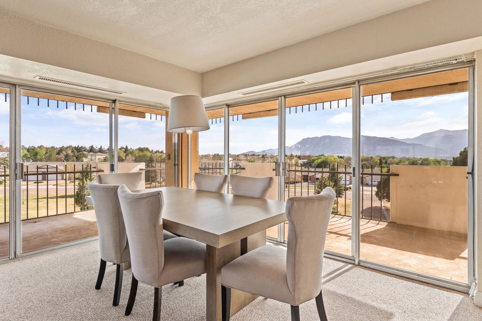 Step into your light-filled dining area, where floor-to-ceiling windows frame stunning mountain and countryside views, creating the perfect backdrop for your meals together.