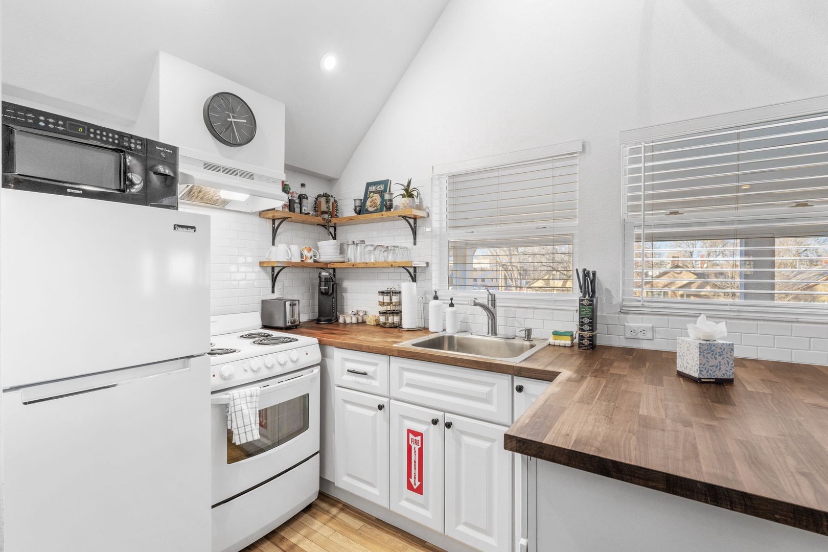Your bright kitchen invites culinary adventures with wood countertops, subway tile backsplash, and everything needed to create memorable meals together.