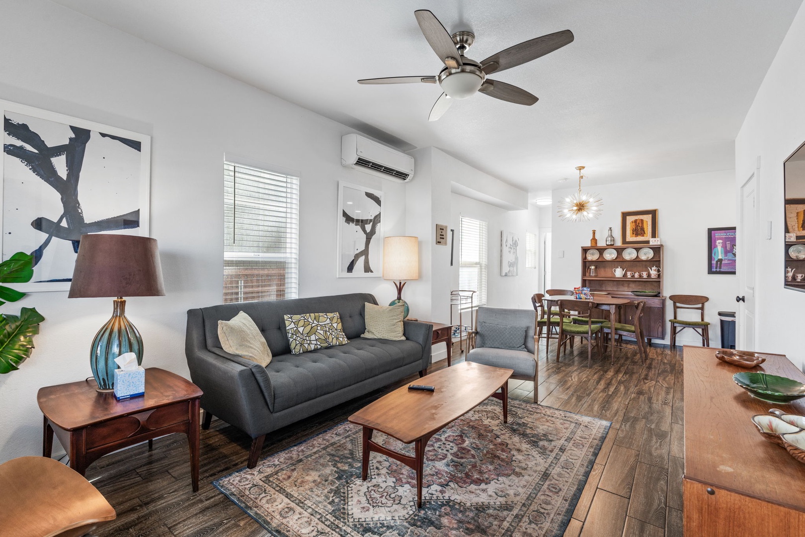 Sink into the comfortable gray sofa while your ceiling fan keeps you cool in this thoughtfully designed living space.