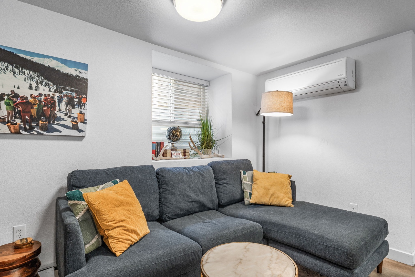 Sink into your plush sectional sofa with vibrant pillows and enjoy the mountain-themed artwork above your head.