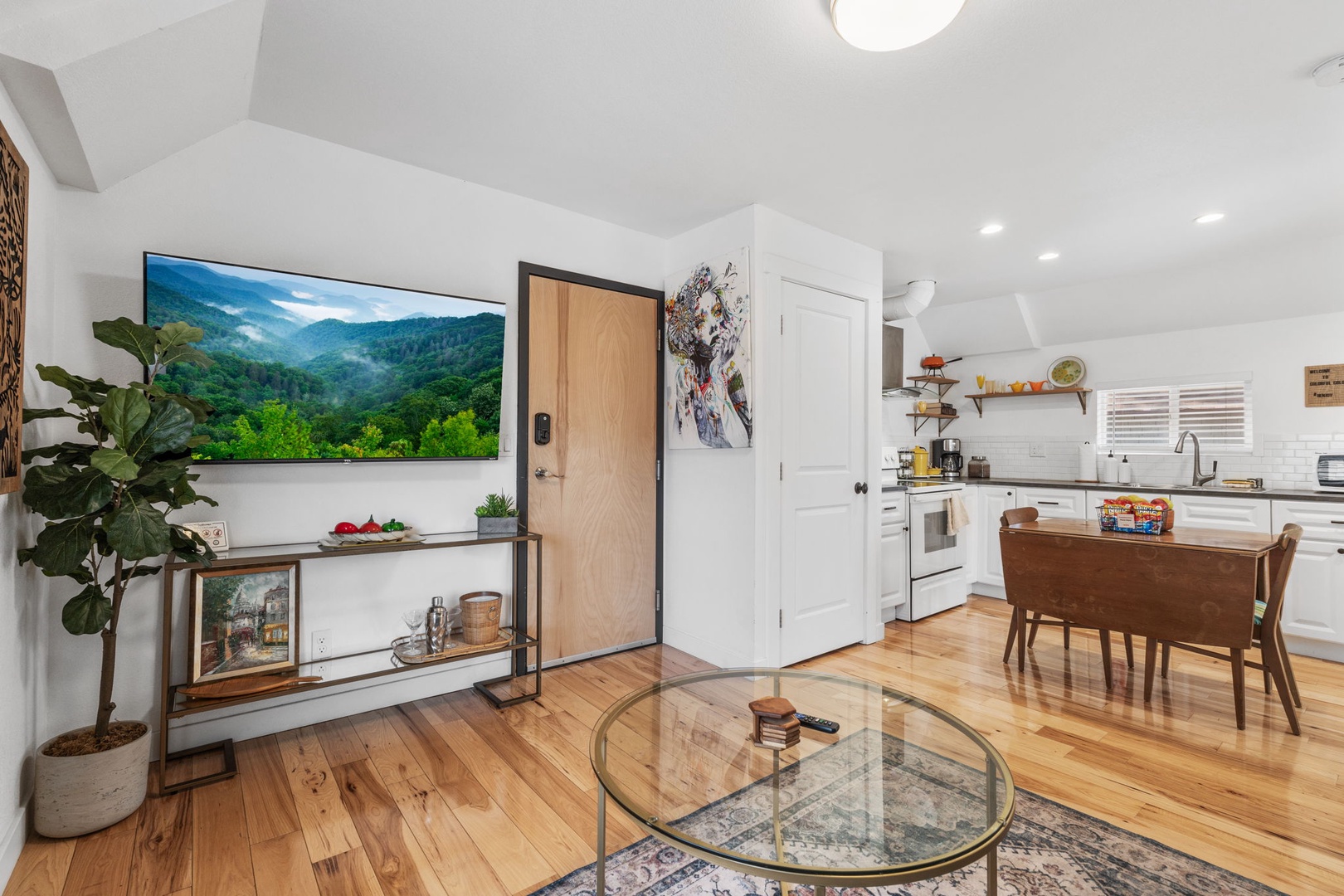 Relax in your bright, open living space with gleaming hardwood floors, modern kitchen, and cozy seating perfect for unwinding after exploring.