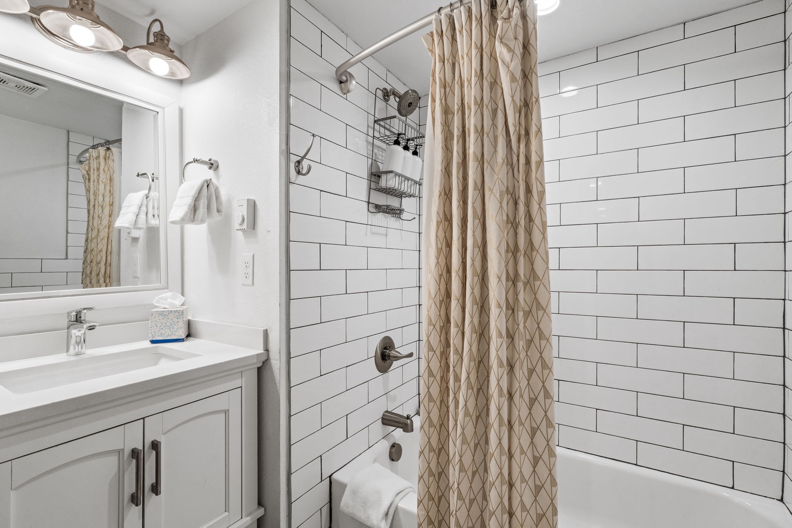 Step into your pristine bathroom sanctuary with elegant subway tiles, plush towels, and a refreshing tub-shower combo ready for your relaxation.