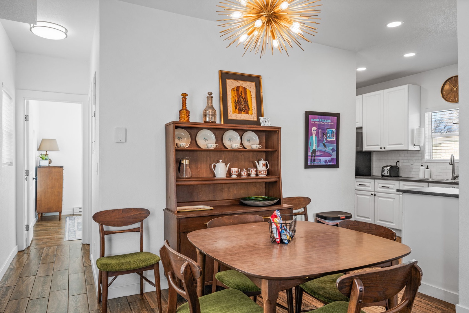 Gather around your elegant dining space, where vintage charm meets modern comfort beneath a stunning starburst chandelier.