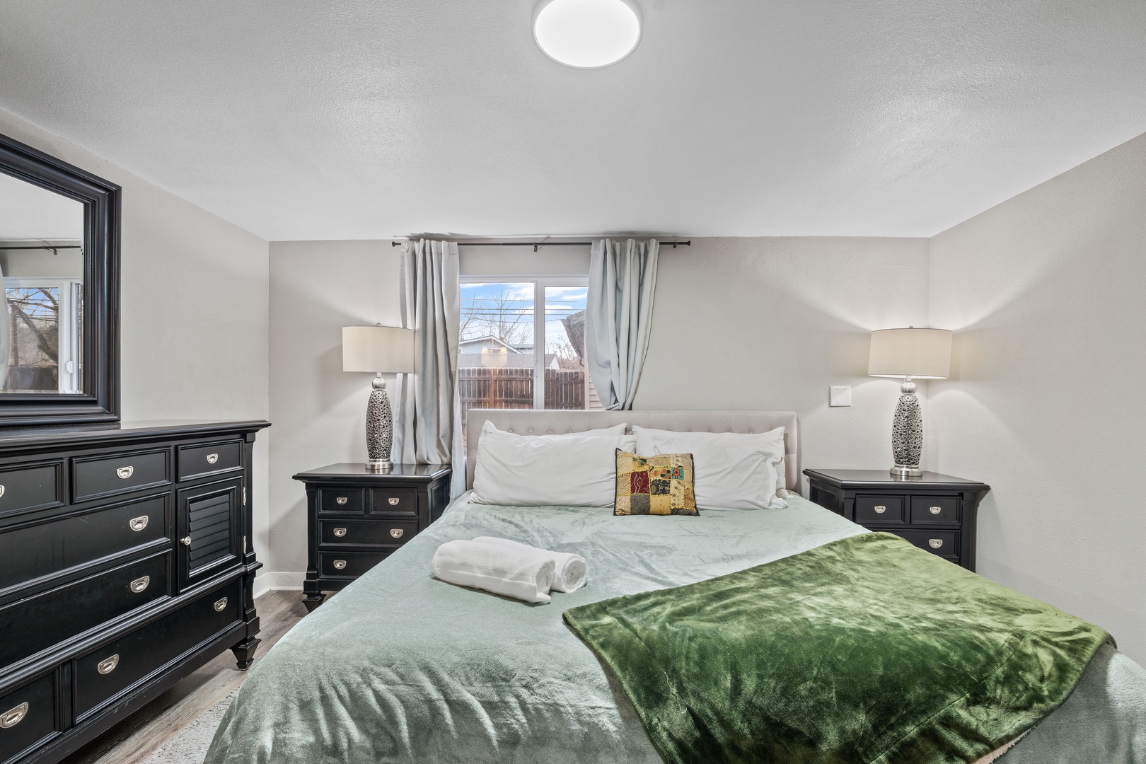 Relax in your serene bedroom featuring elegant dark wood furnishings, soft lighting, and comfortable bedding for a restful night's sleep.