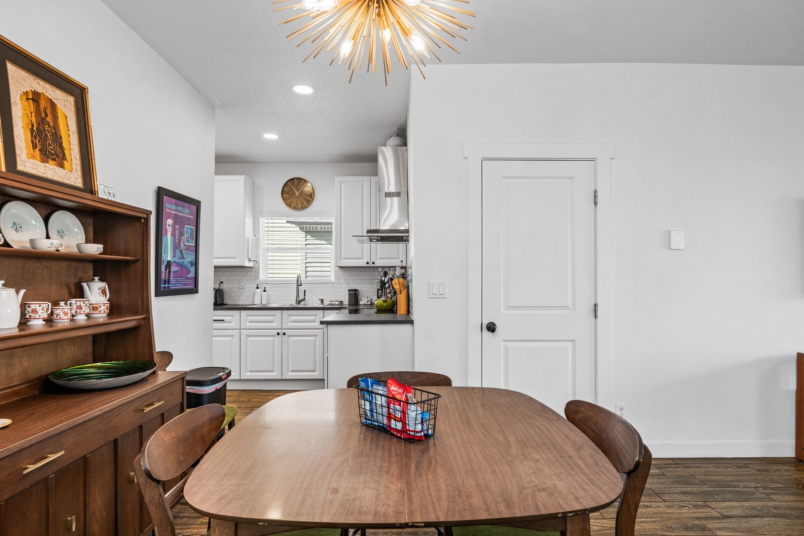 Gather around your stylish dining table beneath the stunning sunburst chandelier, with a fully equipped kitchen just steps away for memorable meals.