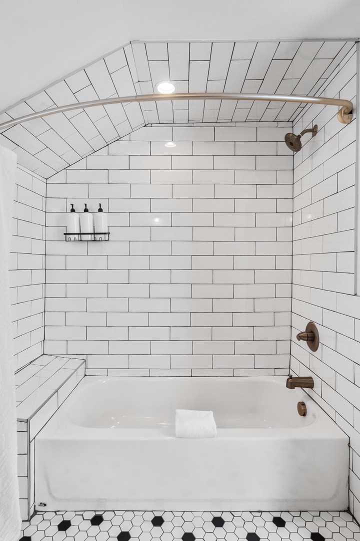 Unwind in your beautiful tiled bathtub surrounded by classic subway tiles and modern brass fixtures.