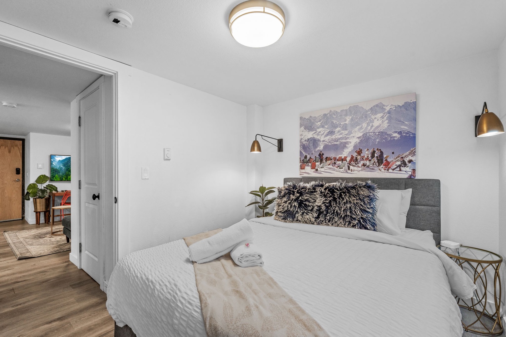 Slip into crisp white linens and drift off beneath inspiring mountain art in your serene bedroom retreat.