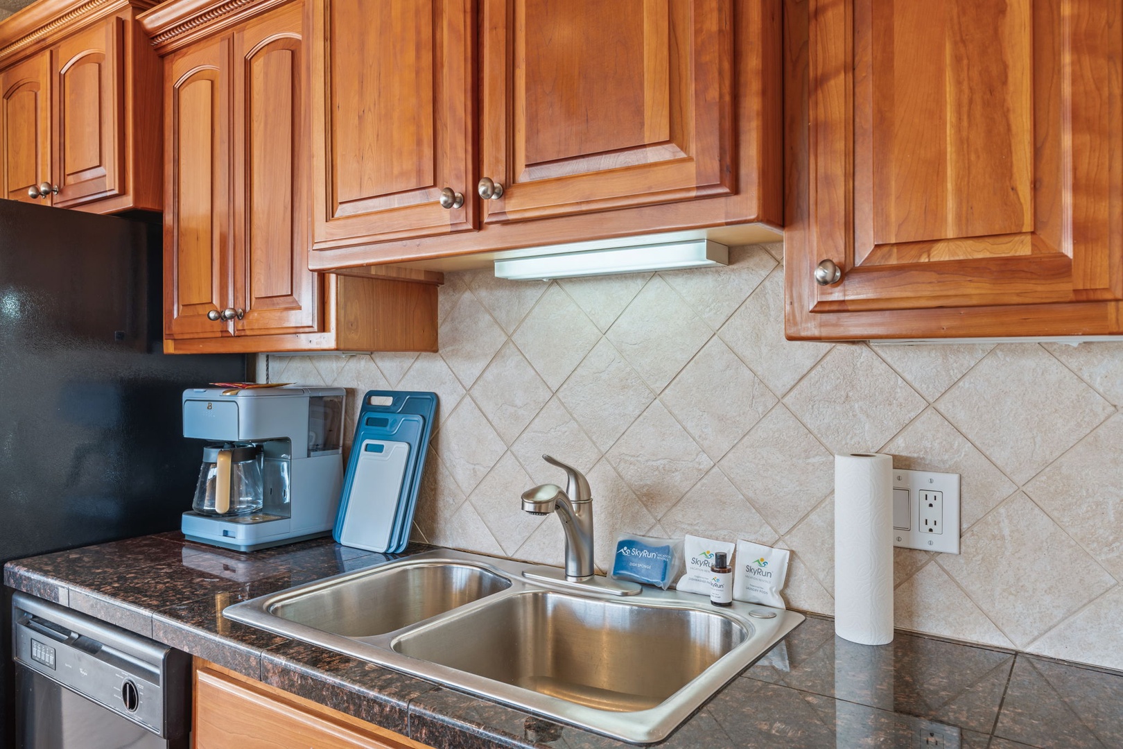 Wake up to fresh coffee made just how you like it in your fully equipped kitchen with modern appliances and warm wood cabinetry.