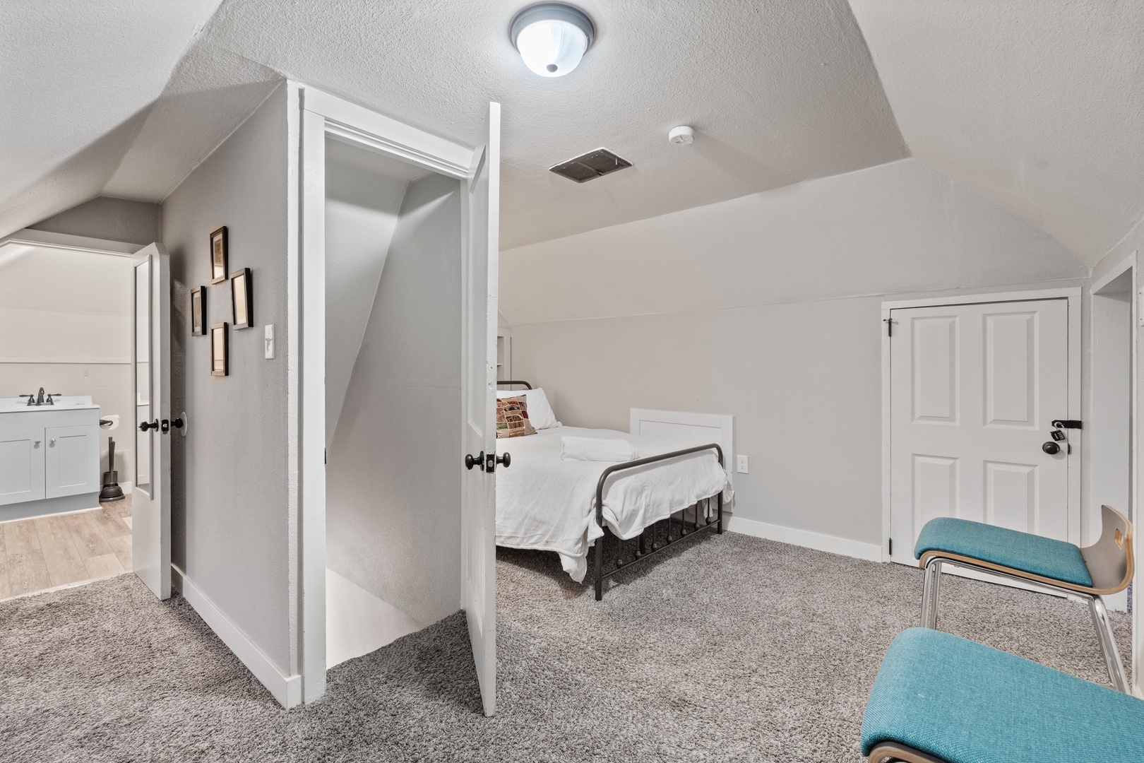 Your peaceful attic bedroom features sloped ceilings and modern comfort, with an ensuite bathroom for your convenience.