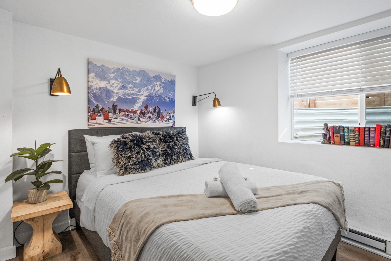 Sink into plush bedding and drift off beneath mountain art while golden pendant lights create the perfect reading ambiance.