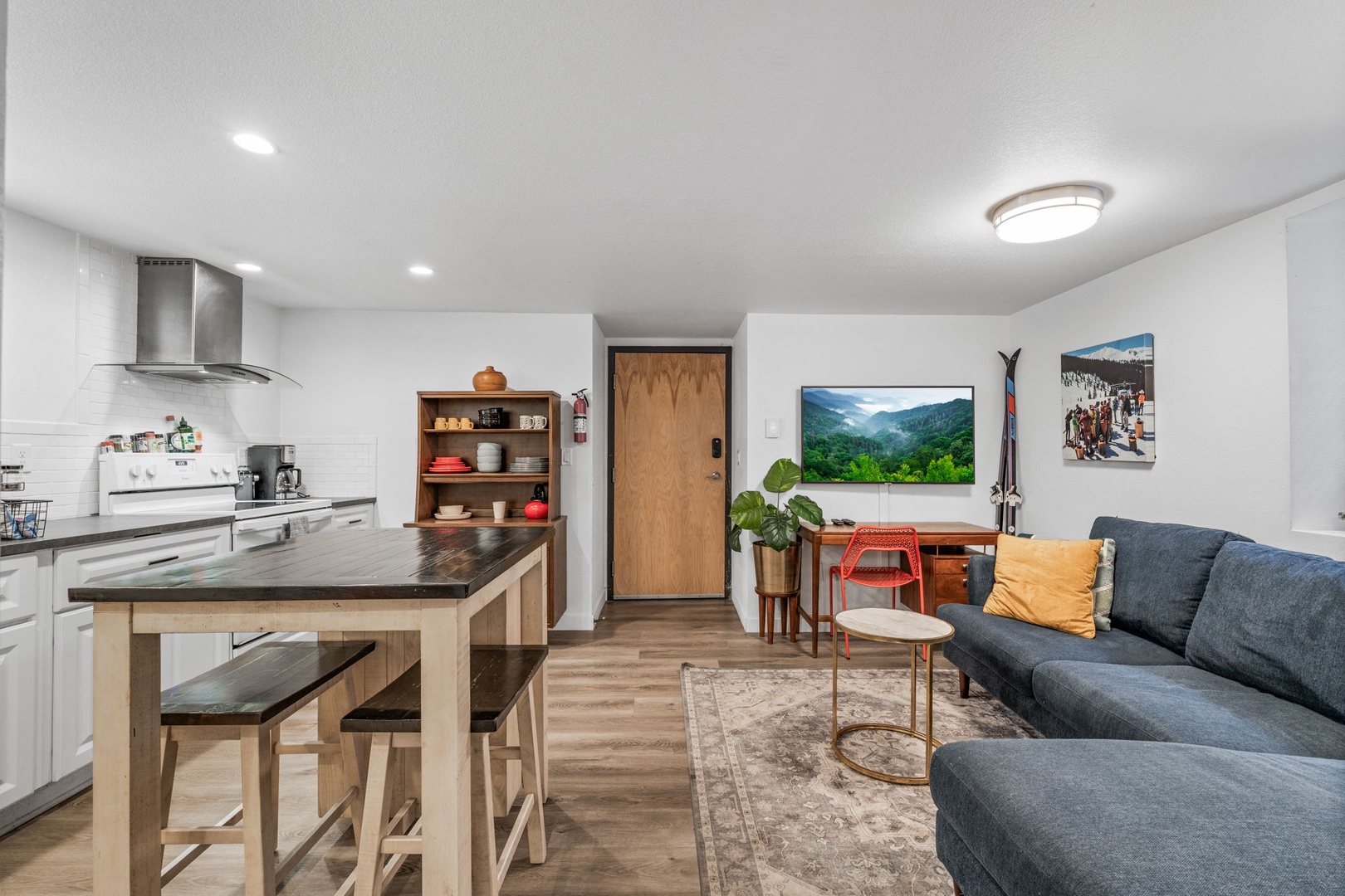 Relax in your modern open-concept space where sleek kitchen flows into cozy living area with plush sectional and mountain views.