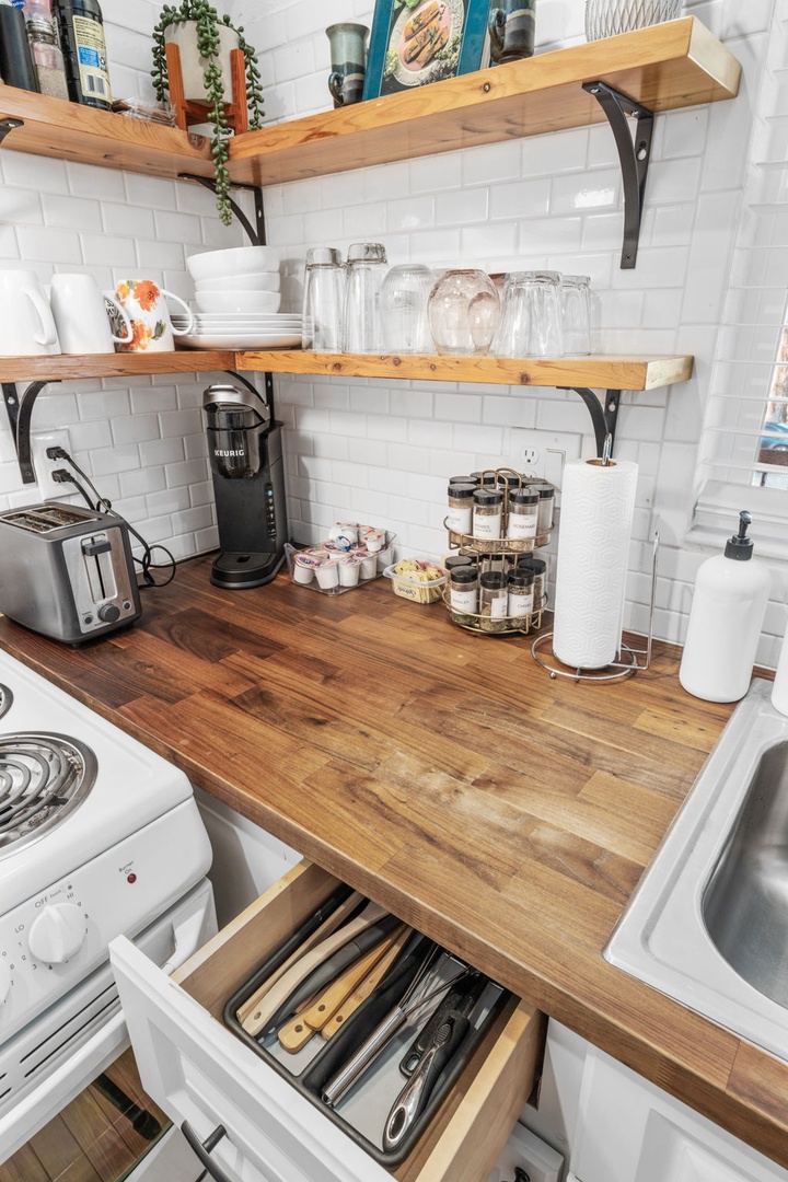 Your fully equipped kitchen features warm wood counters, open shelving, and everything you need to create memorable meals during your stay.