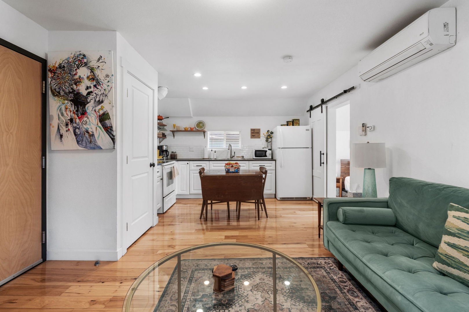 Relax in your stylish open-plan space where the emerald sofa invites afternoon lounging while your fully-equipped kitchen awaits your culinary adventures.