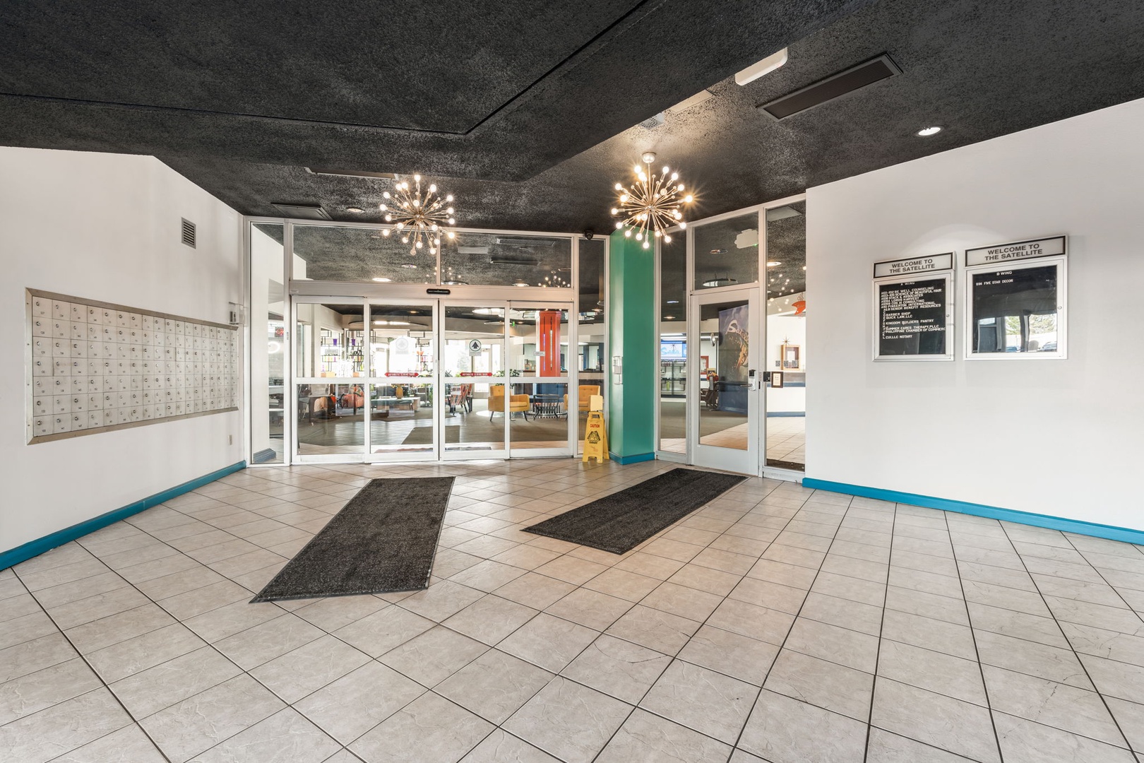 Modern entrance lobby with striking starburst chandeliers and easy access to the main property areas, creating an inviting first impression upon arrival.