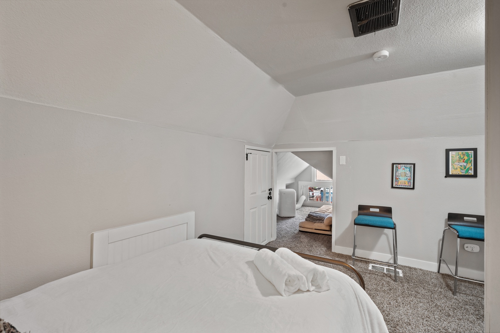 Your cozy bedroom features comfortable seating and connects to additional living spaces, creating a welcoming retreat for your stay.
