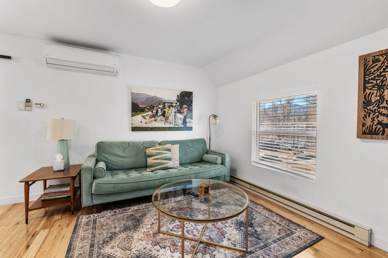 Unwind in your stylish living room featuring a plush sage sofa, vintage rug, and thoughtfully curated artwork—perfect for relaxing after exploring the city.