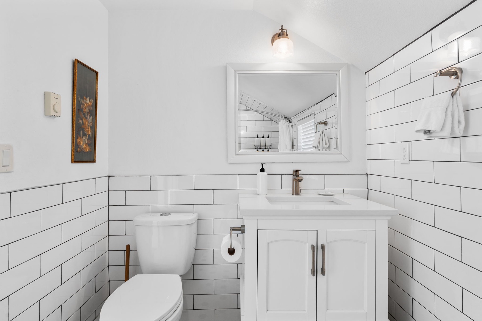 Step into your pristine bathroom featuring classic subway tile and modern amenities that blend style with comfort perfectly.