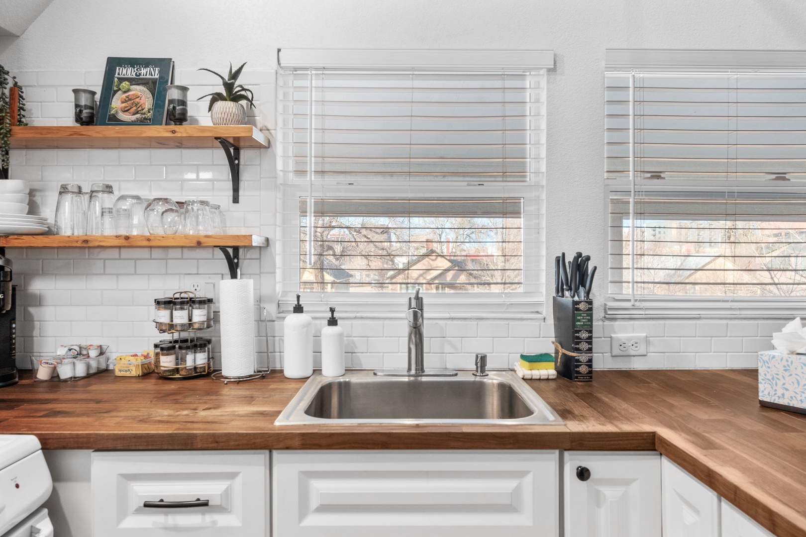 Prepare your favorite meals in this beautifully appointed kitchen with warm wood countertops, modern appliances, and plenty of natural light streaming in.