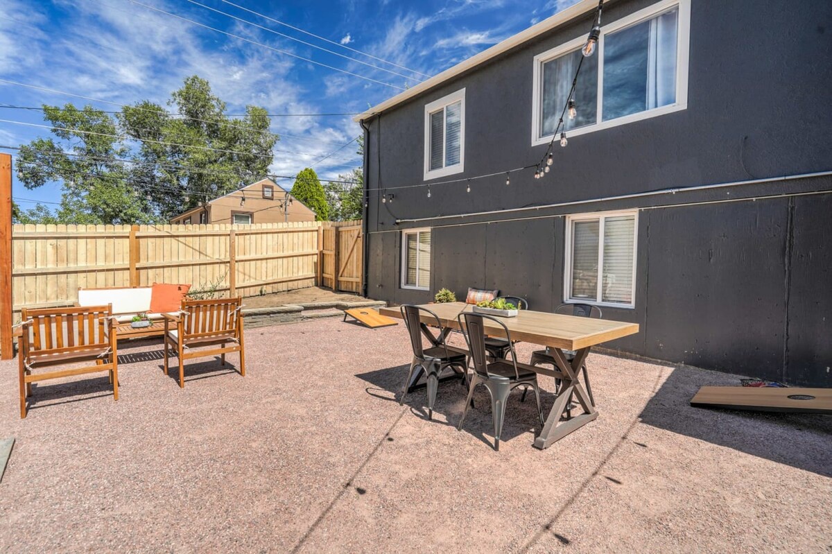 Your private backyard retreat features a dining table for outdoor meals and lounge seating for relaxing under string lights.