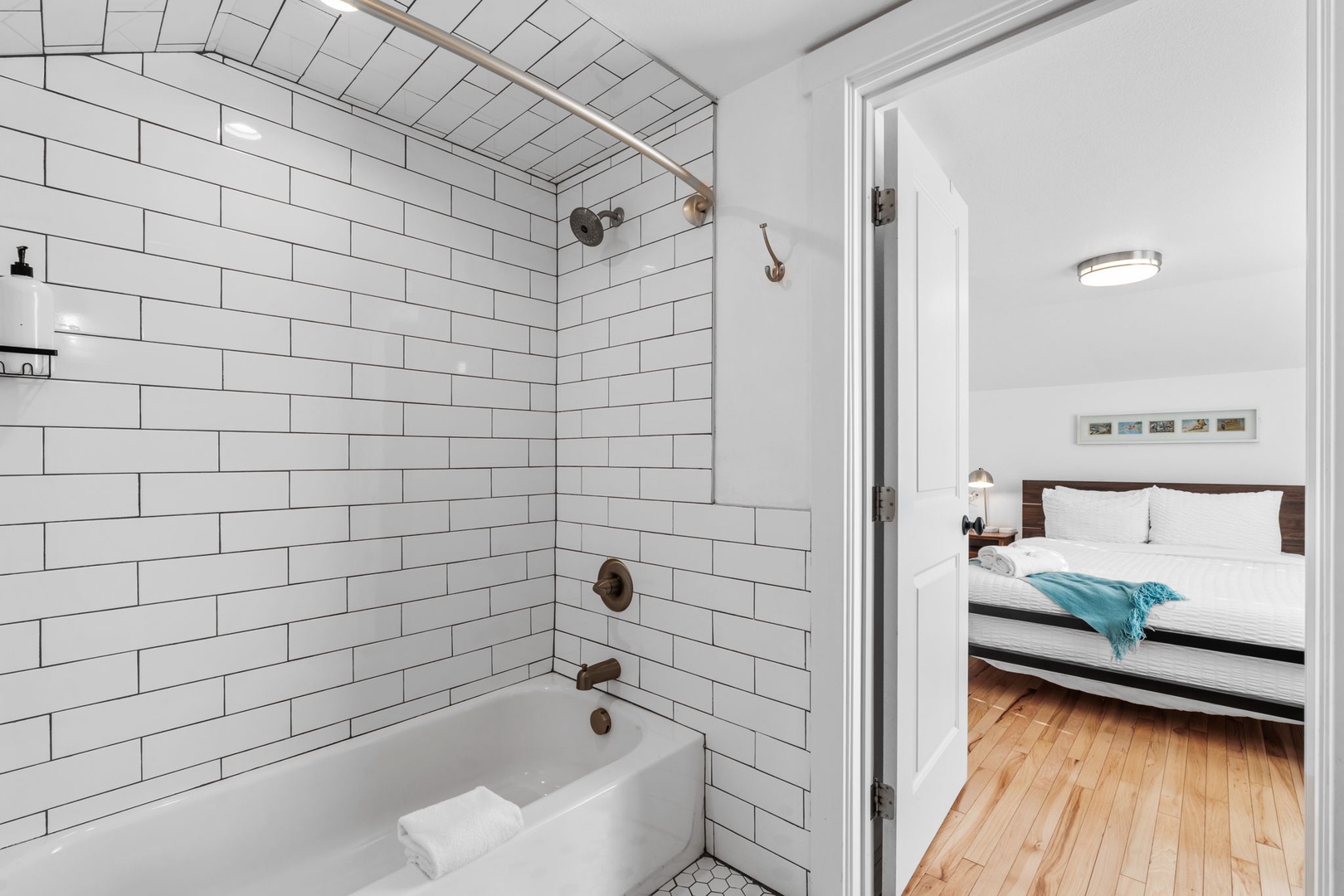 Unwind in your sleek en-suite with classic subway tiles and soaking tub, steps from your cozy bedroom retreat.