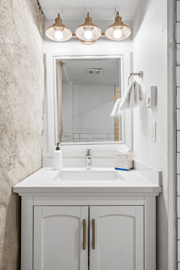 Your elegant bathroom vanity features beautiful lighting and crisp white finishes for a refreshing start to each day.