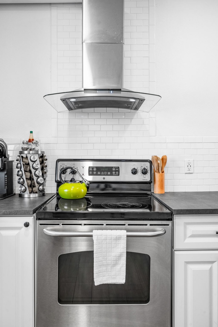 Cook your favorite meals in this sleek modern kitchen featuring stainless steel appliances and elegant white subway tile backsplash.