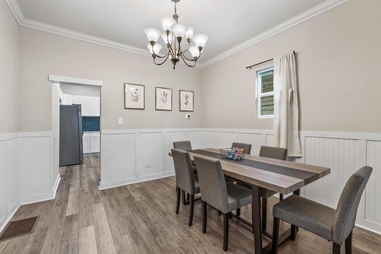 Gather around your elegant dining table under the warm glow of the chandelier for memorable meals together in this beautifully appointed space.