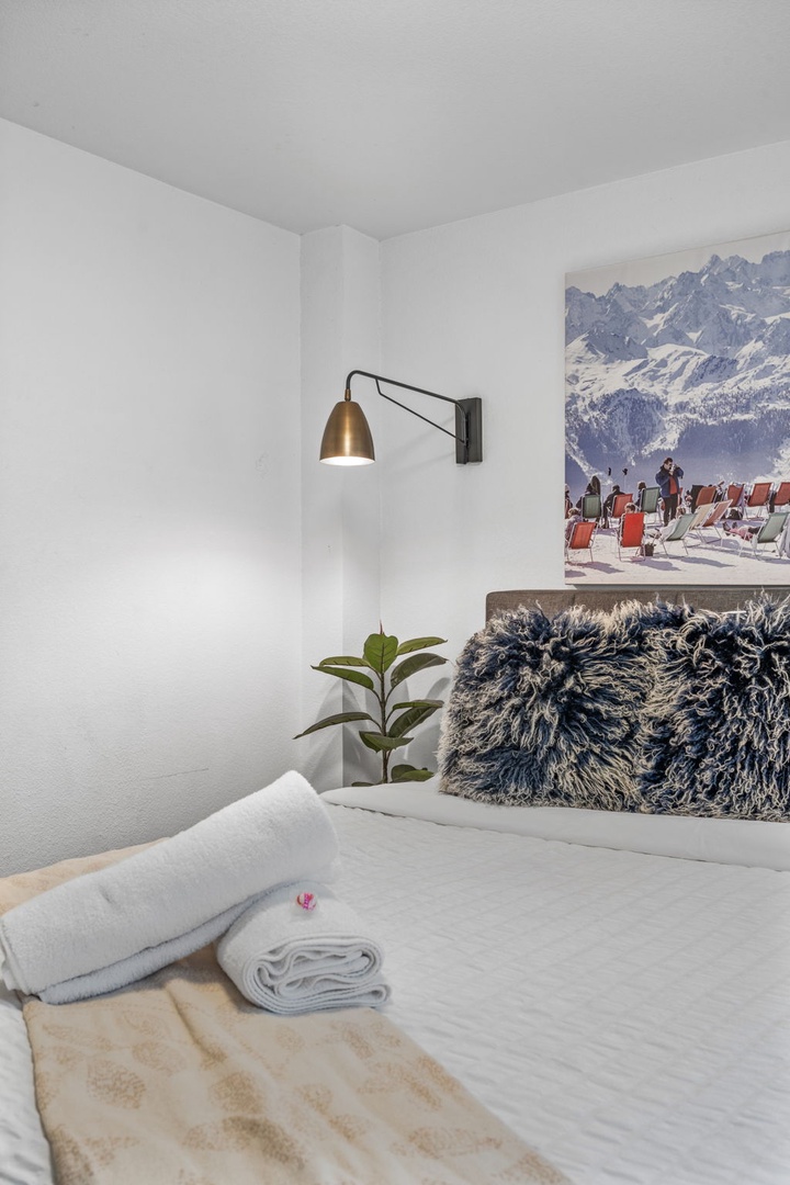 Drift off in your cozy bedroom, where fluffy towels await and mountain artwork inspires alpine dreams.