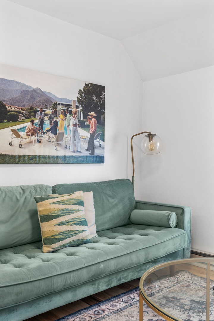 Sink into your stylish living space with a plush sage sofa, designer artwork, and warm brass lighting creating the perfect ambiance for relaxation.