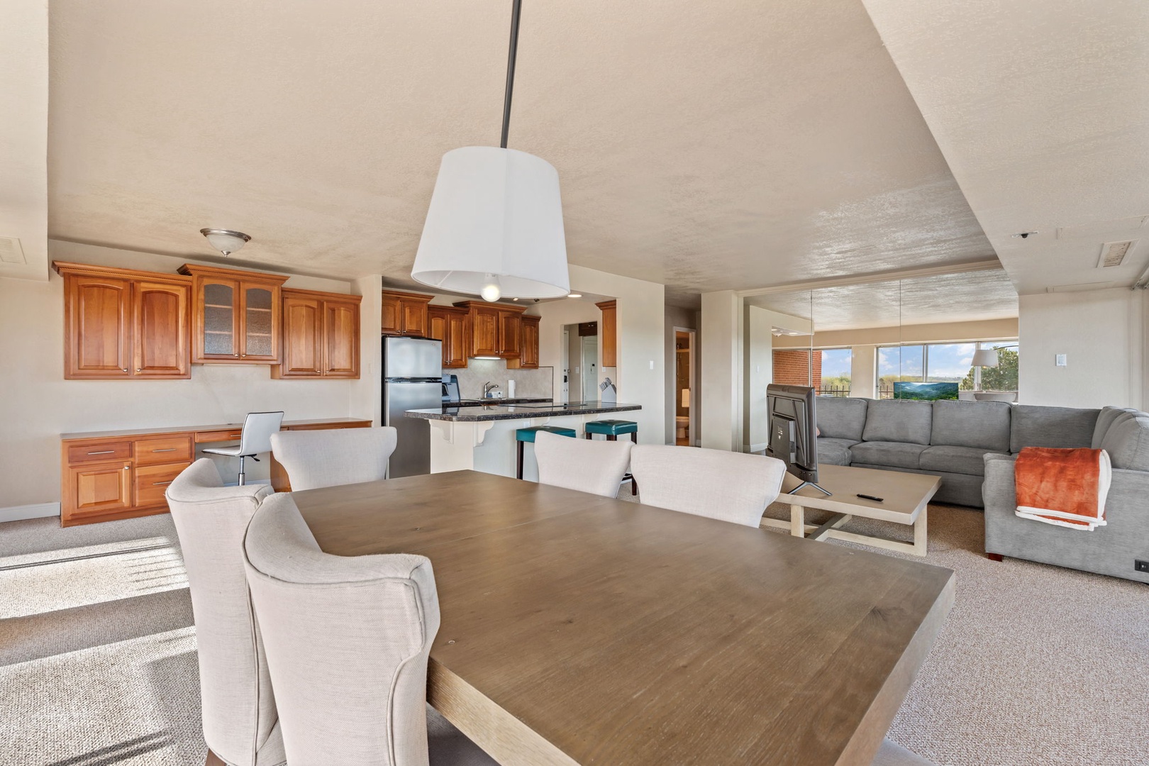 An open-concept space where you can cook, dine, and relax all in one sunlit area. Warm wood cabinetry and modern appliances make meal prep a breeze, while the spacious living room invites you to unwind after a day of exploring.