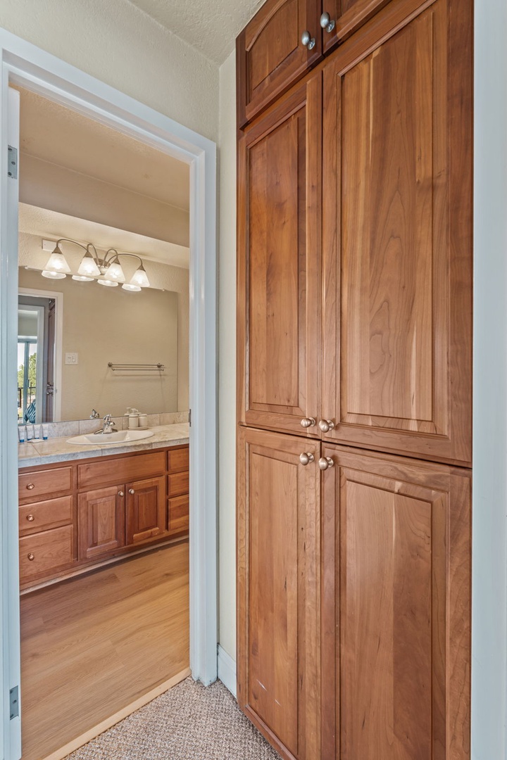 Step into your private suite with generous built-in storage and an ensuite bathroom featuring warm wood cabinetry and soft lighting for your comfort.