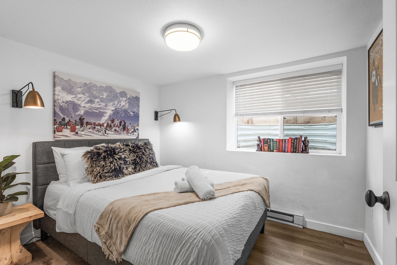 Sink into your cozy bedroom with plush bedding, alpine artwork, and warm reading lights for the perfect mountain getaway.