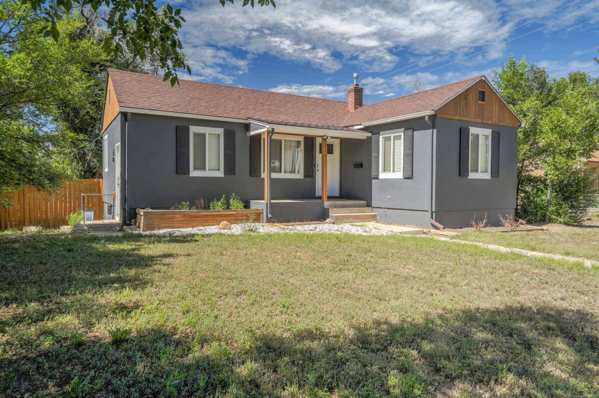 Charming single-story home with covered front porch and spacious yard, nestled in a quiet residential neighborhood surrounded by mature trees.