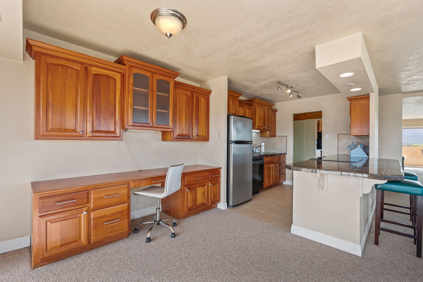 Prepare your favorite meals in this spacious, well-equipped kitchen featuring elegant wood cabinetry, granite countertops, and stainless steel appliances—everything you need for a comfortable stay.