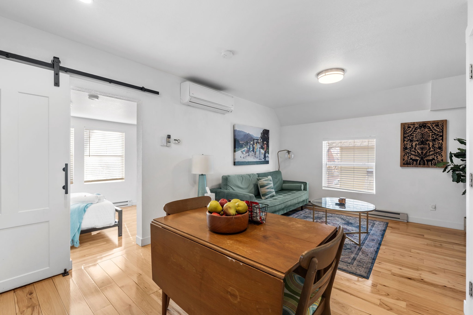 Relax in your bright, open-plan living space with modern furnishings, artwork, and convenient AC comfort for your perfect getaway.