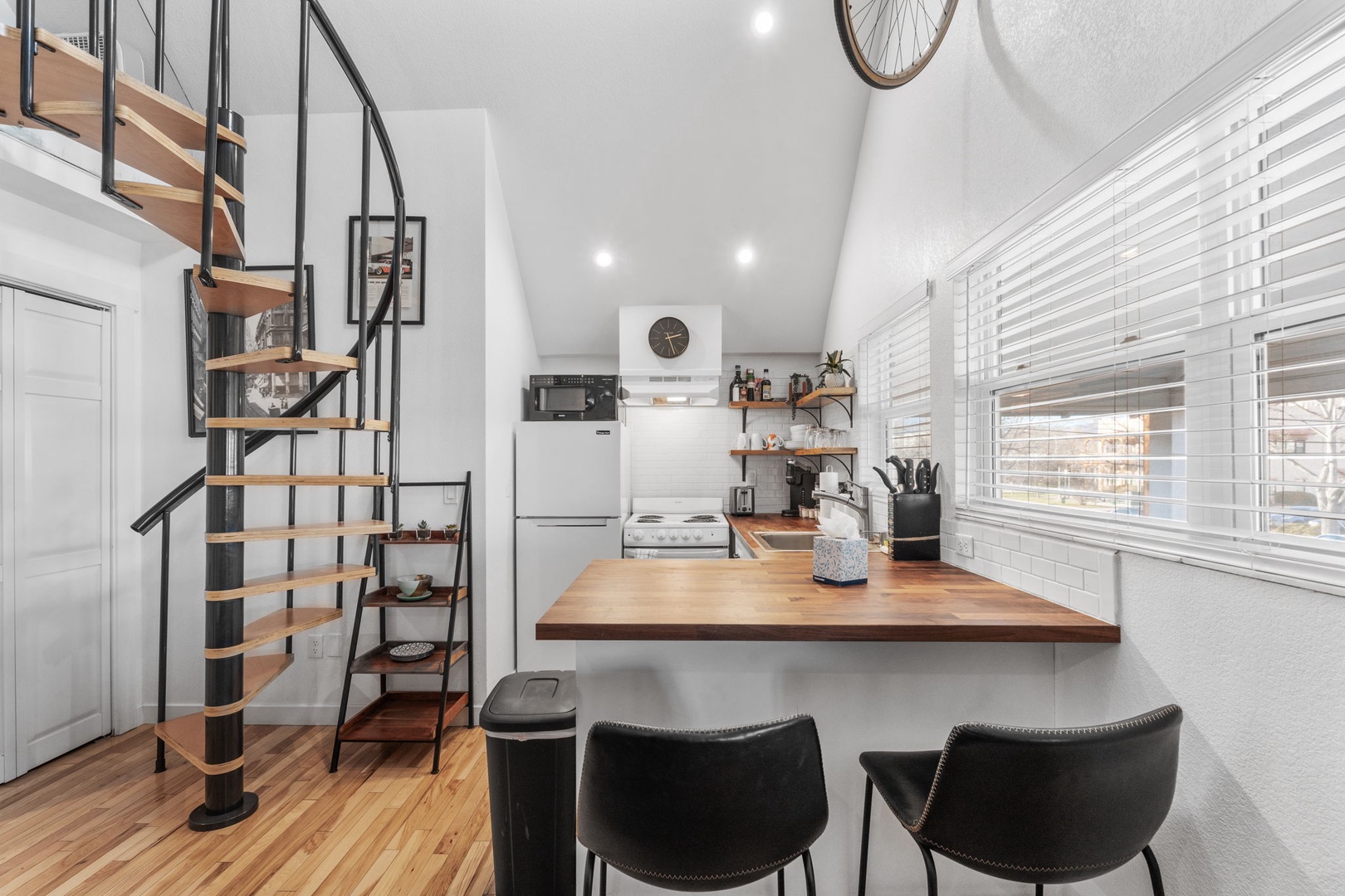 Cook, dine, and unwind in your modern kitchen featuring warm wood counters, stylish bar seating, and an airy open layout perfect for memorable meals.