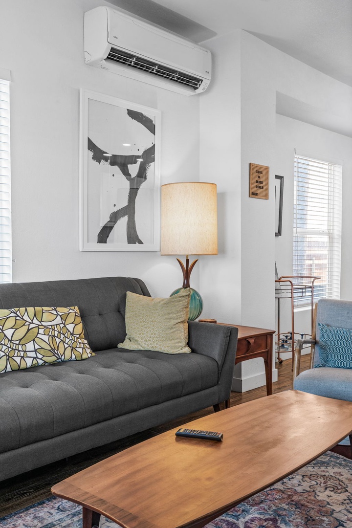 Sink into the cozy gray sofa and enjoy your comfortable retreat with modern amenities and stylish touches.