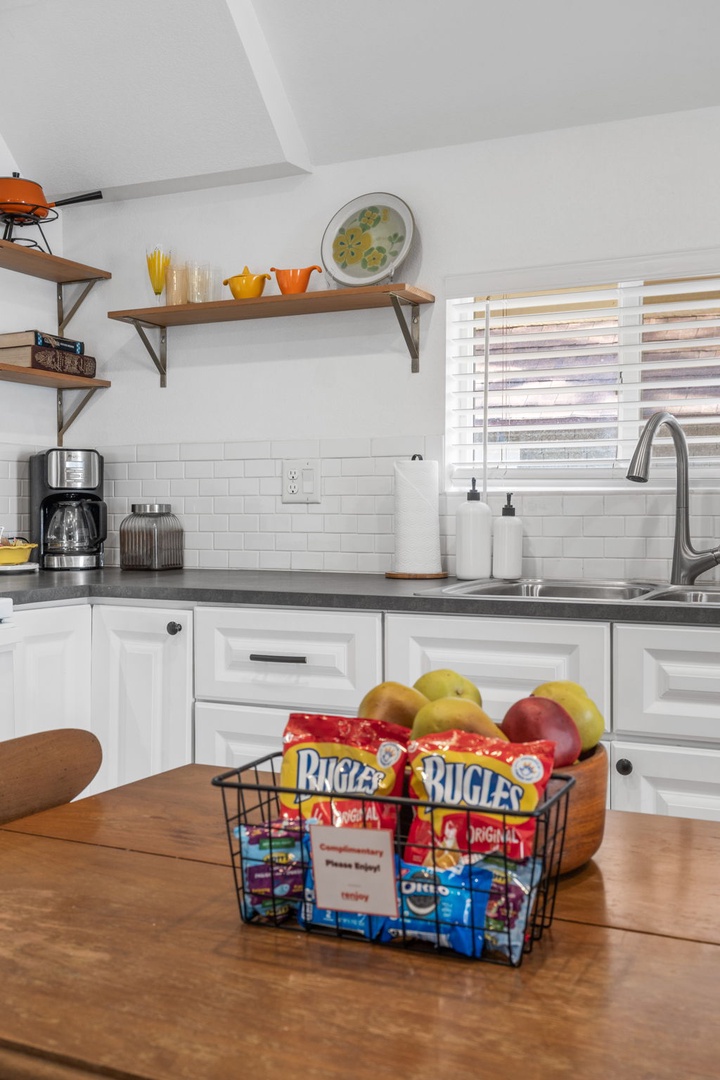 Your bright kitchen welcomes you with white cabinets, modern appliances, and charming open shelving displaying cheerful dishware.