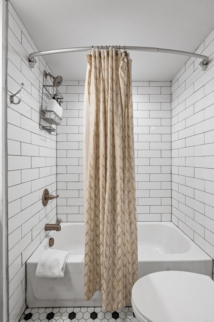 Step into your stylish bathroom with classic subway tile walls and a relaxing tub for unwinding after exploring.
