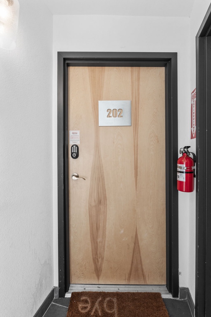 Modern entrance to room 202 with secure keyless entry and clean hallway design.