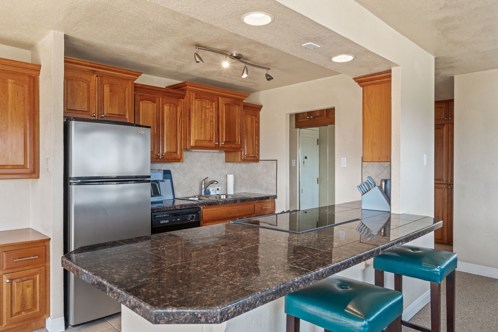 Step into this inviting kitchen with warm wood cabinetry, gleaming granite counters, and a spacious island where you can gather for meals and conversation.
