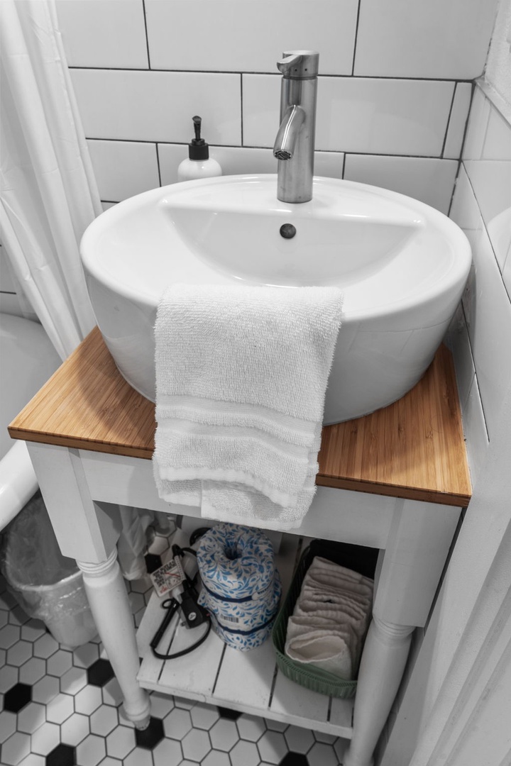 Your ensuite sink combines style and practicality, with fluffy towels and thoughtful storage below.