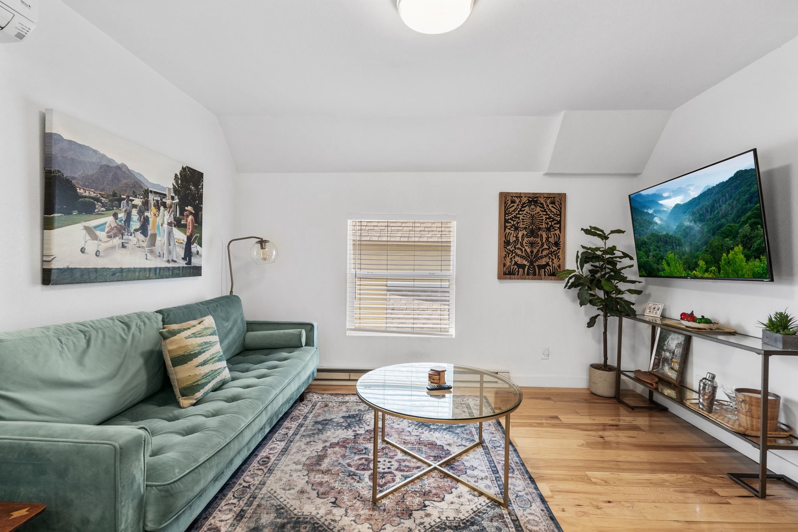 Sink into the plush sage sofa and unwind in your stylish living room, complete with modern entertainment and thoughtful decor touches.