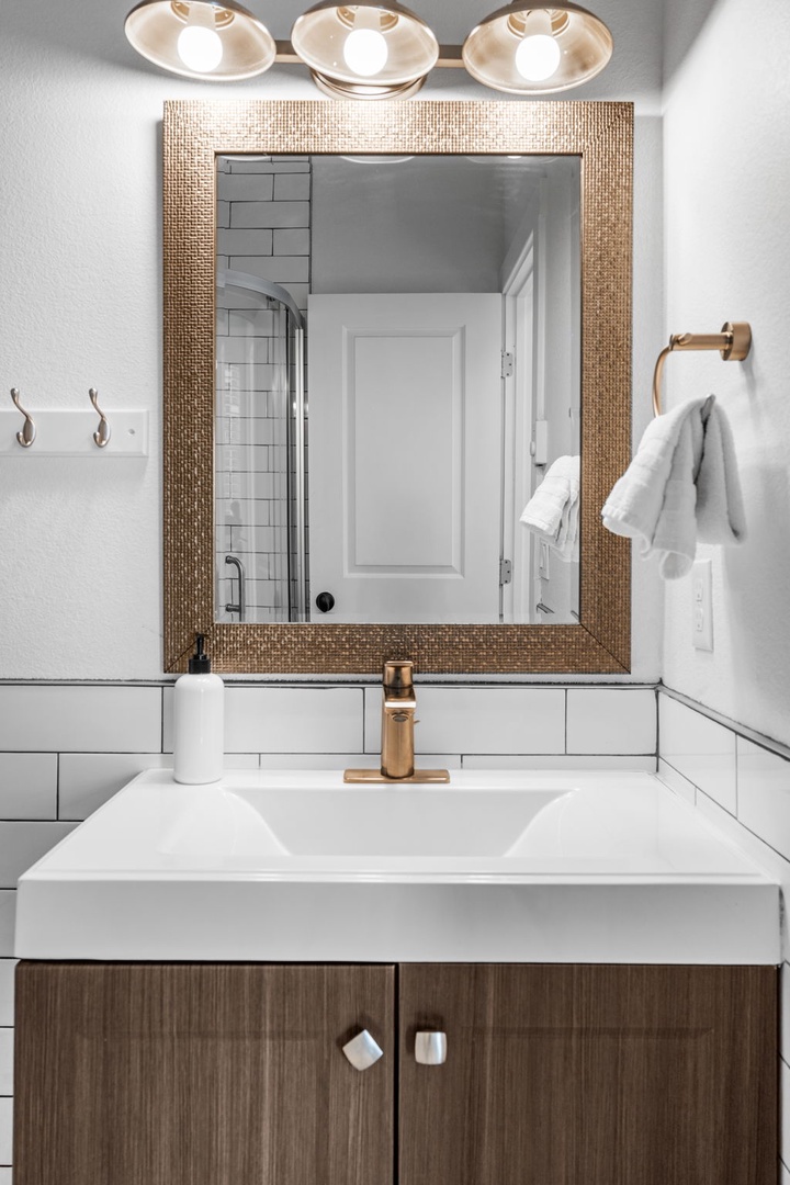 Step into your beautifully appointed bathroom featuring warm gold accents, crisp white subway tiles, and plush towels waiting for your arrival.