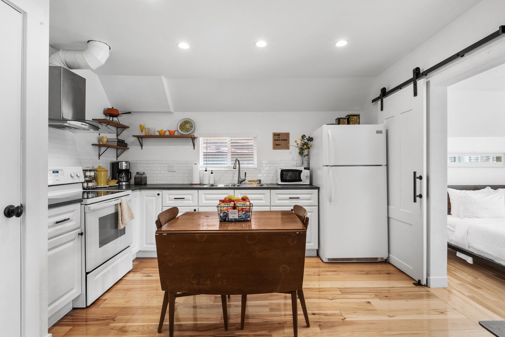 Your bright open kitchen flows seamlessly into dining, with warm wood floors and modern appliances ready for memorable meals together.
