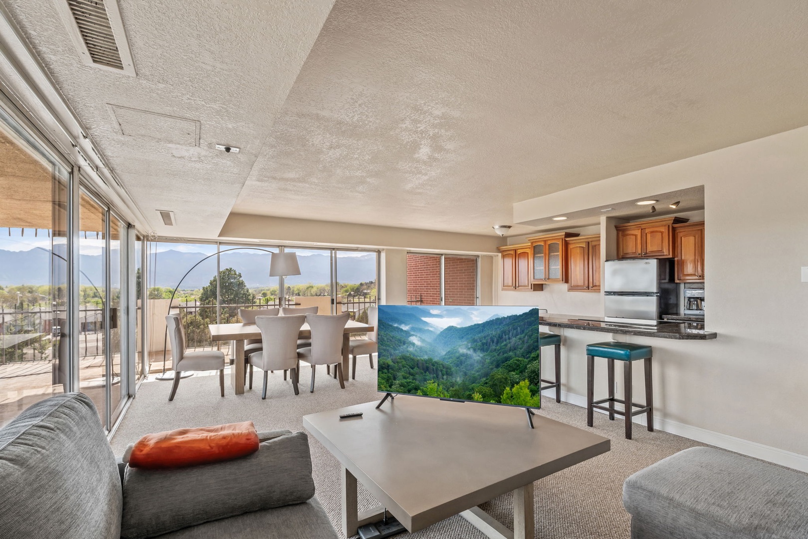 Step into your bright, spacious retreat with floor-to-ceiling mountain views. Relax in the open living space, prepare meals in the full kitchen, and unwind on your private balcony.